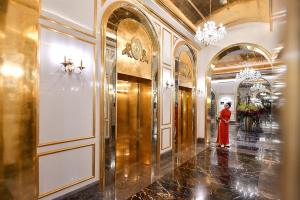 A staff member stands near the lifts in the lobby of the newly-inaugurated Dolce Hanoi Golden Lake hotel, the world's first gold-plated hotel, in Hanoi on July 2, 2020.CREDIT: MANAN VATSYAYANA/AFP VIA GETTY IMAGES