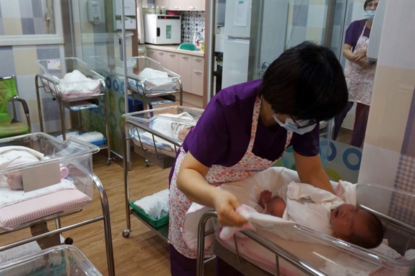 Một y tá chăm sóc một em bé tại trung tâm hậu sản nằm trong Bệnh viện Đa khoa Haenam, Hàn Quốc. Ảnh: The Straits Times.