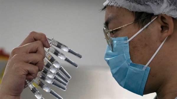 Một công nhân kiểm tra ống tiêm vaccine COVID-19 do Sinovac sản xuất tại nhà máy ở Bắc Kinh. Ảnh: AP.