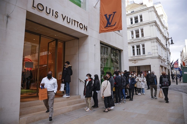 Người mua sắm xếp hàng bên ngoài một cửa hàng Louis Vuitton ở London vào ngày 12.4 khi các cửa hàng không thiết yếu mở cửa trở lại sau gần 100 ngày đóng cửa. Ảnh: Bloomberg.