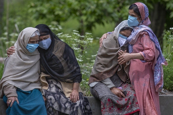 Những người phụ nữ an ủi các thành viên trong gia đình của một nạn nhân COVID-19 tại Srinagar, Ấn Độ. AP.