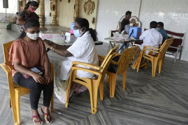 Một nhân viên y tế tiêm vaccine COVID-19 cho một phụ nữ ở ngoại ô Hyderabad, Ấn Độ. Ảnh: AFP.