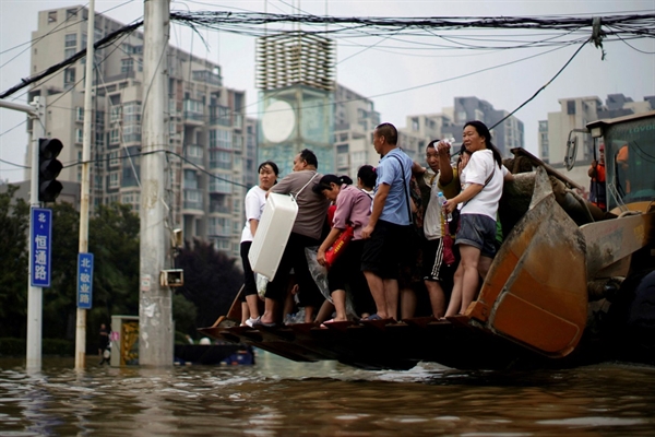 Nhiều người đi trên một chiếc xe tải khi họ vượt qua dòng nước lũ sau trận mưa lớn ở Trịnh Châu, Hà Nam, Trung Quốc. Ảnh: Reuters.