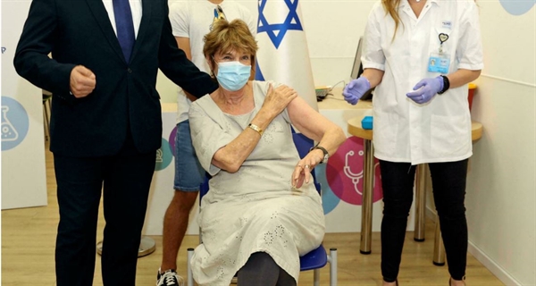 Thủ tướng Israel Naftali Bennett đưa thân mẫu đến chích liều vaccine thứ 3 tại Haifa, Israel, ngày 3/8/2021. Ảnh: AP.