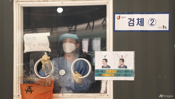 Một nhân viên y tế trong quầy xét nghiệm COVID-19 xịt chất khử trùng ở Seoul, Hàn Quốc ngày 4/8/2021. Ảnh: AP.
