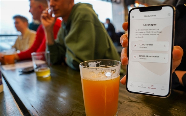 Một người xuất trình coronapas tại quán bar ở Copenhagen. Ảnh: AFP.