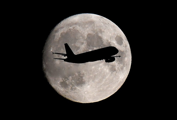 Một máy bay chở khách đi qua phía trước mặt trăng khi nó hạ cánh cuối cùng xuống Sân bay Heathrow ở London, Anh ngày 12/9/2019. Ảnh: Reuters.
