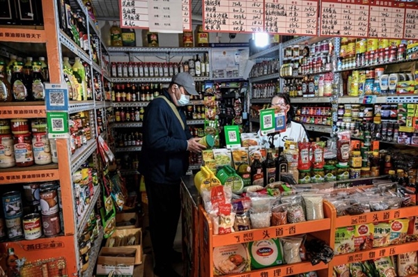 Một người đàn ông mua các loại gia vị thực phẩm tại một khu chợ lân cận ở Bắc Kinh hôm 2/11. Ảnh: AFP.