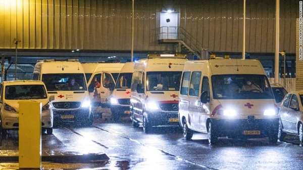 Các nhân viên y tế của Hội Chữ thập đỏ vận chuyển hành khách bị nhiễm COVID-19, đến khu kiểm dịch của một khách sạn sau khi trở về Hà Lan từ Nam Phi. Ảnh: CNN.