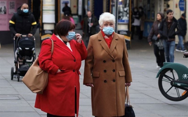 Người dân đeo khẩu trang chờ sang đường ở London, Anh, ngày 21/12/2021. Ảnh: Reuters.