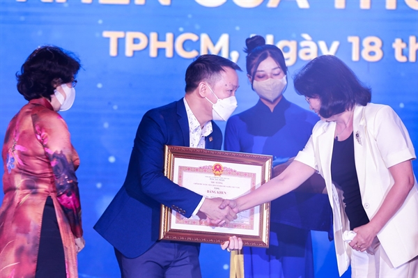 Nguyên Phó Chủ tịch nước Đặng Thị Ngọc Thịnh (phải) và Chủ tịch  UBMTTQVN TP Tô Thị Bích Châu (trái) trao bằng khen của Thủ tướng cho ông Huỳnh Văn Tẩn.