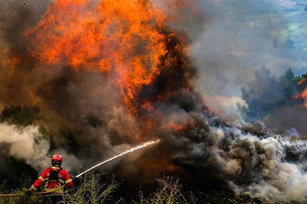 Một lính cứu hỏa giải quyết ngọn lửa xung quanh làng Ancede trong trận cháy rừng ở thành phố Baiao, Bồ Đào Nha, vào ngày 15/07. Ảnh: Hugo Delgado.