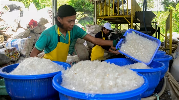 Một công nhân đang phân loại hạt nhựa để tái chế ở Bogor, Indonesia. Ảnh: AP.