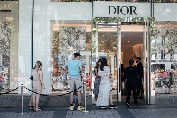 Khách hàng xếp hàng để vào một cửa hàng sang trọng của Christian Dior. Ảnh: Bloomberg.