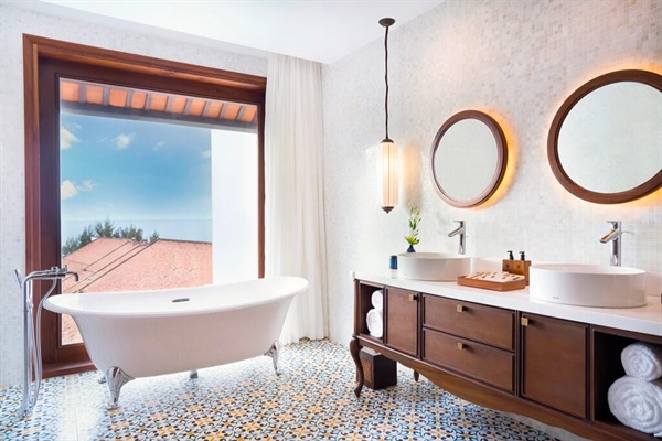Phòng tắm được trang trí bằng đá phiến xám hoặc gạch khảm, bồn tắm chân đế cổ điển và vòi sen.