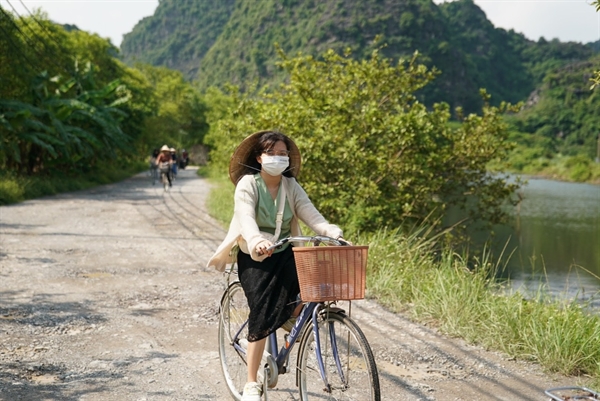 lựa chọn đi bộ, đi xe đạp hoặc sử dụng phương tiện giao thông công cộng để di chuyển, nhằm hạn chế khí thải ra môi trường. Ảnh: TL.