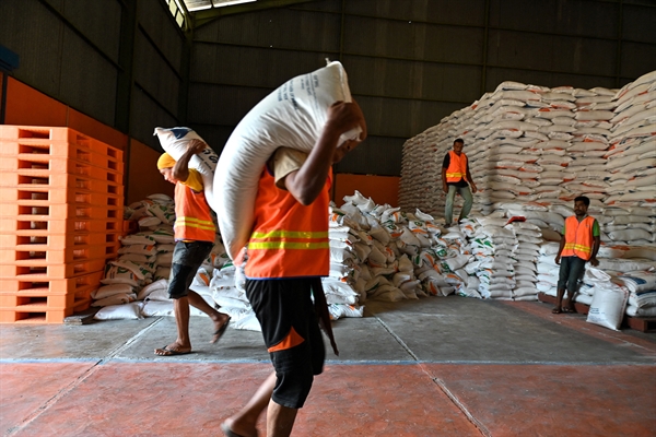 Công nhân khuân vác các bao gạo nhập khẩu từ Thái Lan tại một nhà kho của Cục Xuất nhập khẩu Indonesia. Ảnh: AFP.