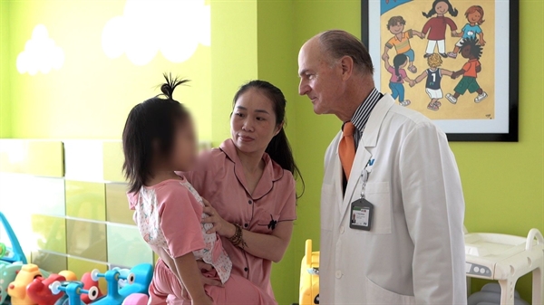 Giáo sư McKinnon thăm bé Nhi sau phẫu thuật (Ảnh: FV)