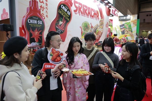 6. (Chọn 1 trong 2). Thực khách Nhật Bản thích thú dùng thử sản phẩm tại Foodexjpg