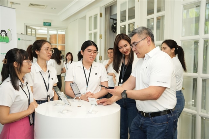 Lãnh đạo ngân hàng cùng khách mời trải nghiệm thao tác đăng ký trên ứng dụng CUB Vietnam. Ảnh: CUB.