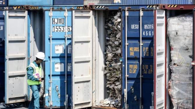 Một quan chức Malaysia kiểm tra một container chứa đầy rác thải nhựa trước khi gửi đến Westport ở Port Klang vào năm 2019. Ảnh: AP.