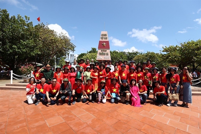 Đoàn công tác của Ủy ban Nhà nước về NVNONN và đại biểu kiều bào chụp ảnh lưu niệm tại thị trấn Trường Sa. (Ảnh: Phan Hải)