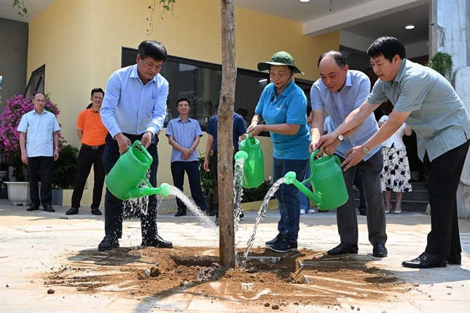 Lãnh đạo FPT và địa phương cùng trồng cây xây trong khuôn viên công trình mới.