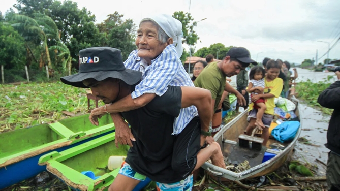 Một phụ nữ lớn tuổi được một nhân viên cứu hộ tình nguyện bế khi người dân được sơ tán đến nơi an toàn hơn ở thị trấn Bato, tỉnh Camarines Sur, phía nam Manila, Philippines, vào ngày 23 tháng 10 năm 2024. Hình ảnh Sayat/AFP/Getty