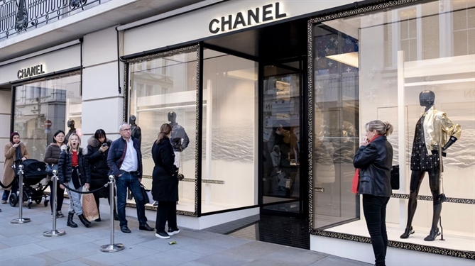 Mọi người xếp hàng bên ngoài cửa hàng flagship Chanel trên phố Bond ở London. Ảnh: Alamy.