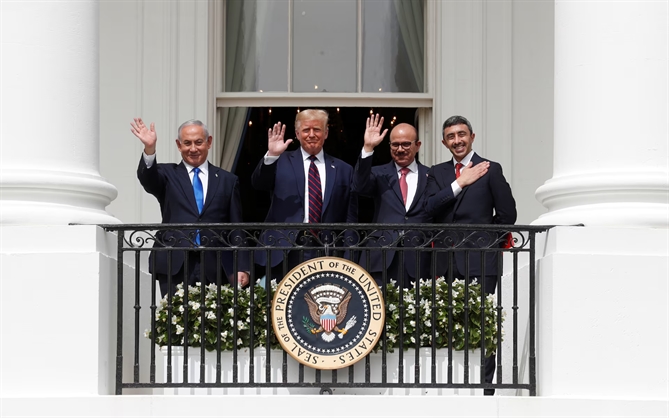 Thủ tướng Israel Benjamin Netanyahu, Tổng thống Donald Trump, Bộ trưởng Ngoại giao Bahrain Abdullatif Al Zayani và Bộ trưởng Ngoại giao Các Tiểu vương quốc Ả Rập Thống nhất (UAE) Abdullah bin Zayed vẫy tay từ ban công Nhà Trắng sau lễ ký kết **Hiệp định Abraham**, thiết lập quan hệ bình thường hóa giữa Israel và một số quốc gia láng giềng Trung Đông, trong một sự điều chỉnh chiến lược các quốc gia Trung Đông nhằm đối phó với Iran, tại Vườn phía Nam của Nhà Trắng ở Washington, vào ngày 15 tháng 9 năm 2020.