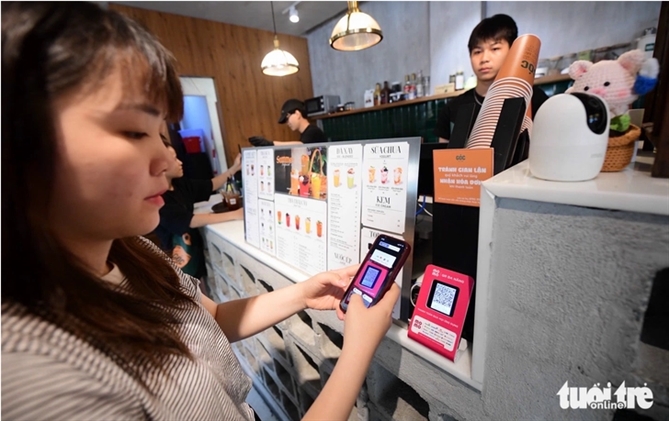 Khách thanh toán chuyển khoản mua cà phê ở quận 1, TP.HCM trưa 2-6 - Ảnh: QUANG ĐỊNH