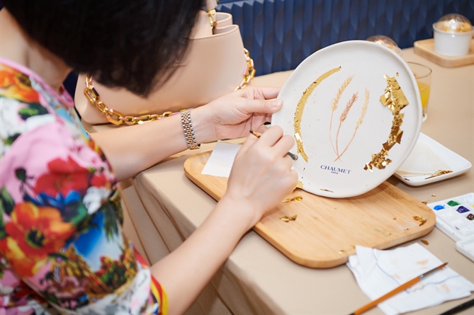 Khách hàng tự tay trang trí đĩa sứ với họa tiết lá vàng – biểu tượng của Chaumet