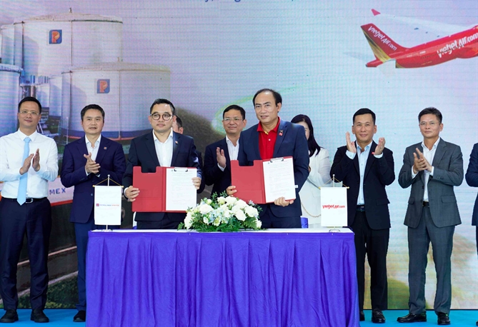 Phó Tổng giám đốc Thường trực Vietjet Tô Việt Thắng (phải) và Tổng Giám đốc Petrolimex Aviation Nguyễn Văn Học (trái) ký kết thỏa thuận hợp tác tiêu thụ Nhiên liệu hàng không bền vững SAF
