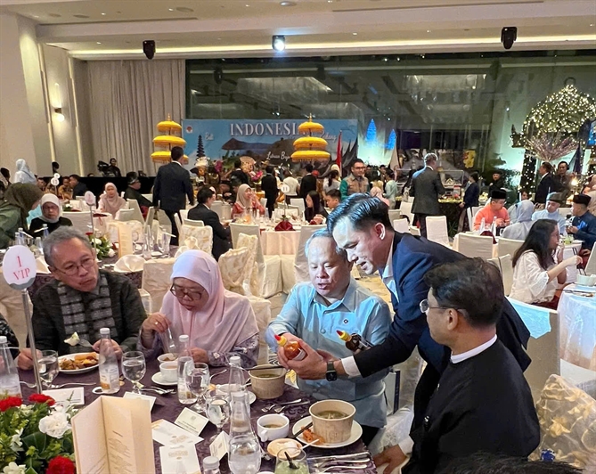 Thực khách quốc tế thưởng thức phở trong không gian tiệc.