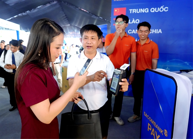 Gian hàng của Sacombank thu hút khách quốc tế tại Lễ hội Tài chính số 2026 Khách tham quan quét mã VIETQRGlobal trên POS SACOMBANK - Ảnh: SACOMBANK